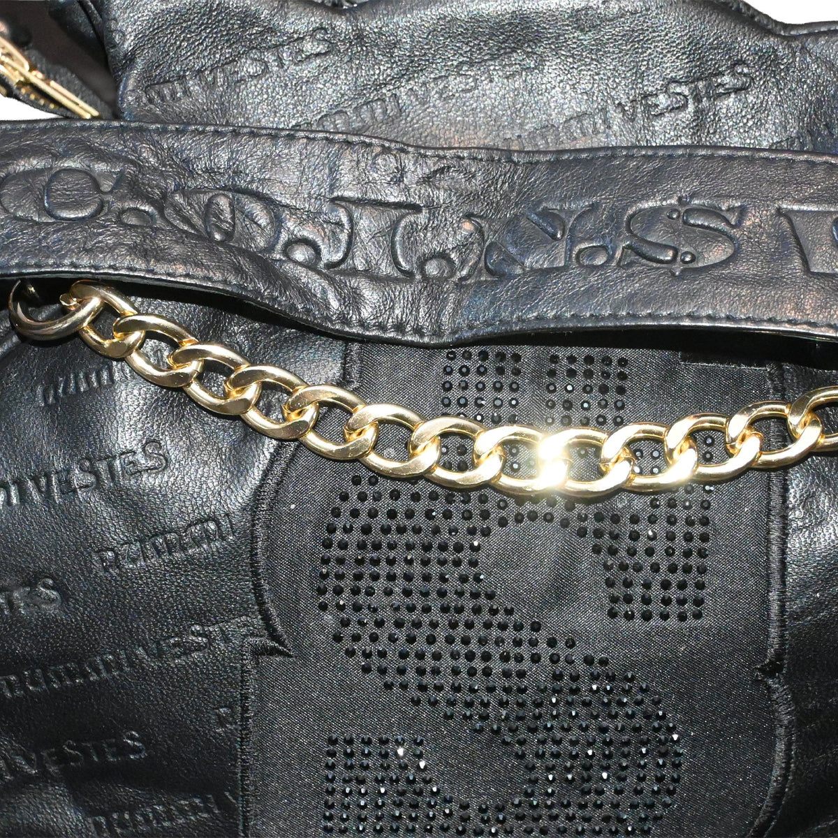 NUMMI VESTES black embossed leather shoulder bag featuring a gold chain strap and crystal-embellished dollar sign logo.