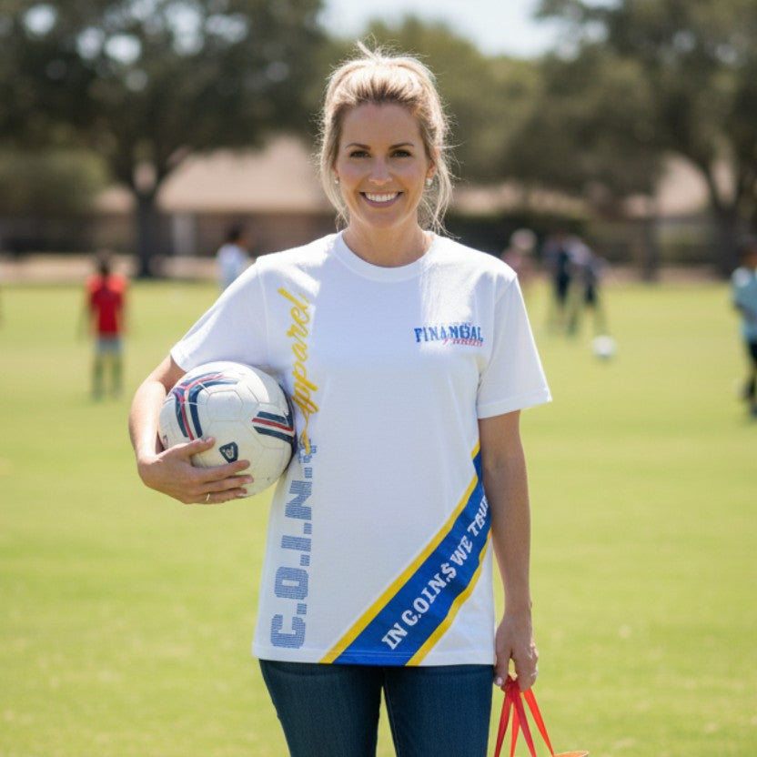 A woman wearing a white NUMMI VESTES graphic crewneck t-shirt with yellow and blue accents, holding a soccer ball.